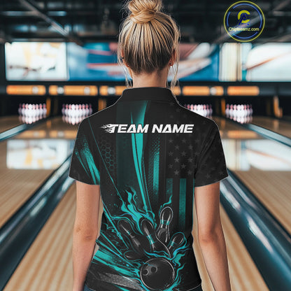 Back view of a female model in a bowling venue wearing a black and turquoise blue polo showcasing a patriotic bowling ball hitting pins design.