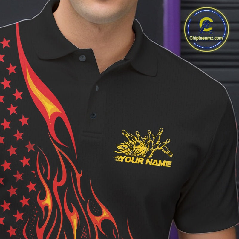 Close-up of the left chest area on a black bowling polo shirt featuring a red-orange flaming bowling ball striking pins with patriotic styling.