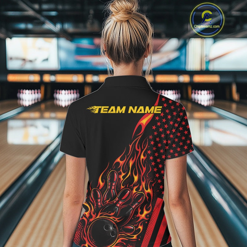 Back view of a female model in a bowling alley wearing a black polo shirt featuring a fiery bowling action scene with patriotic styling.