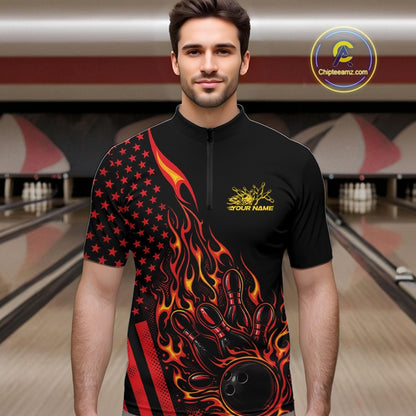 Male model at a bowling lane wearing a black bowling quarter-zip shirt with a red and orange flaming bowling ball striking pins and patriotic American flag artwork.