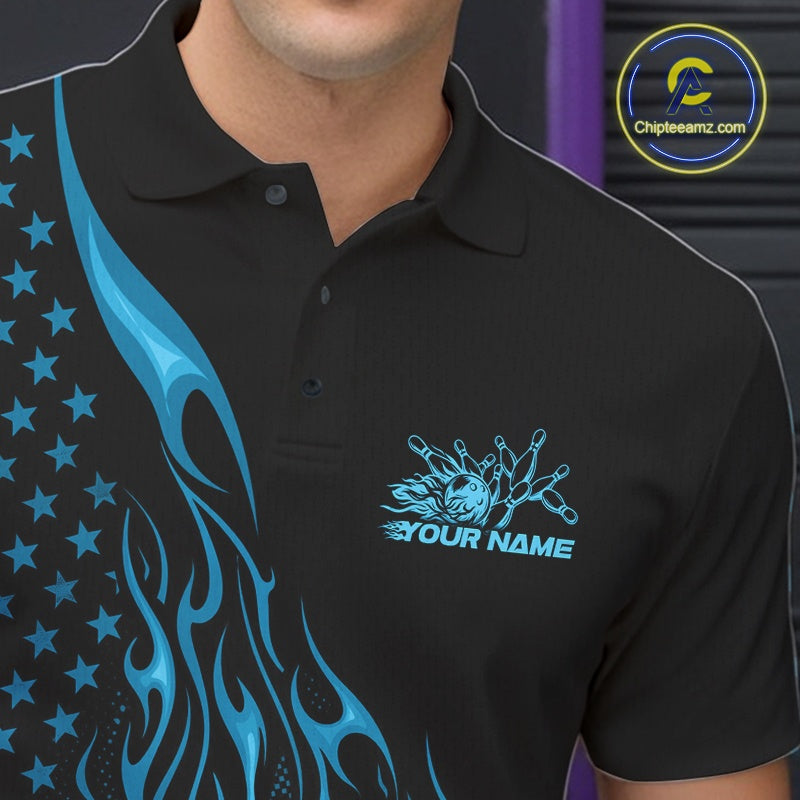 Close-up left chest view of a black bowling polo shirt featuring a blue flaming bowling ball striking pins with patriotic American flag accents.