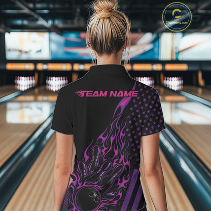 Back view of a female model in a bowling venue wearing a black polo shirt featuring a colorful flaming bowling strike scene.