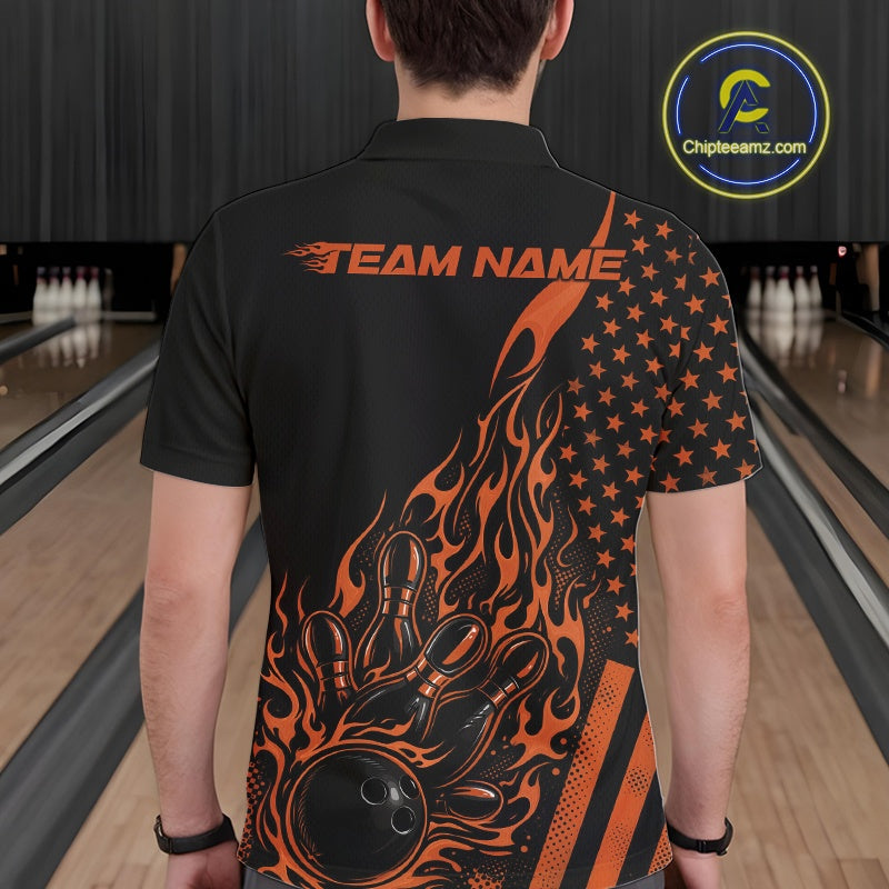 Back view of a male model in a bowling alley wearing a black polo shirt featuring an orange flaming bowling ball and patriotic pin design.