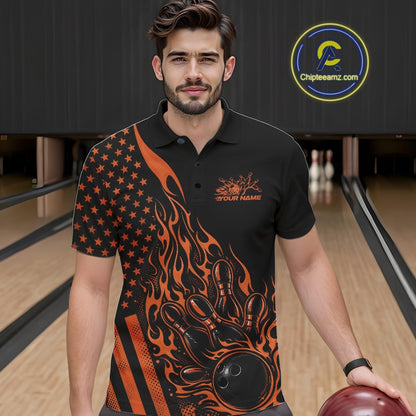 Close-up of the left chest area on a black bowling polo shirt featuring an orange flaming bowling ball striking pins with flag-inspired accents.