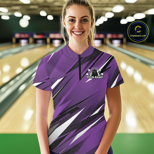 Woman wearing a purple bowling shirt with a logo and text in a bowling alley.