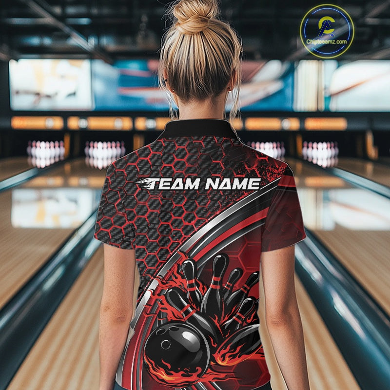 Back view of a black and red women s bowling quarter zip with honeycomb pattern and flame bowling ball knocking down pins artwork inside a bowling center.
