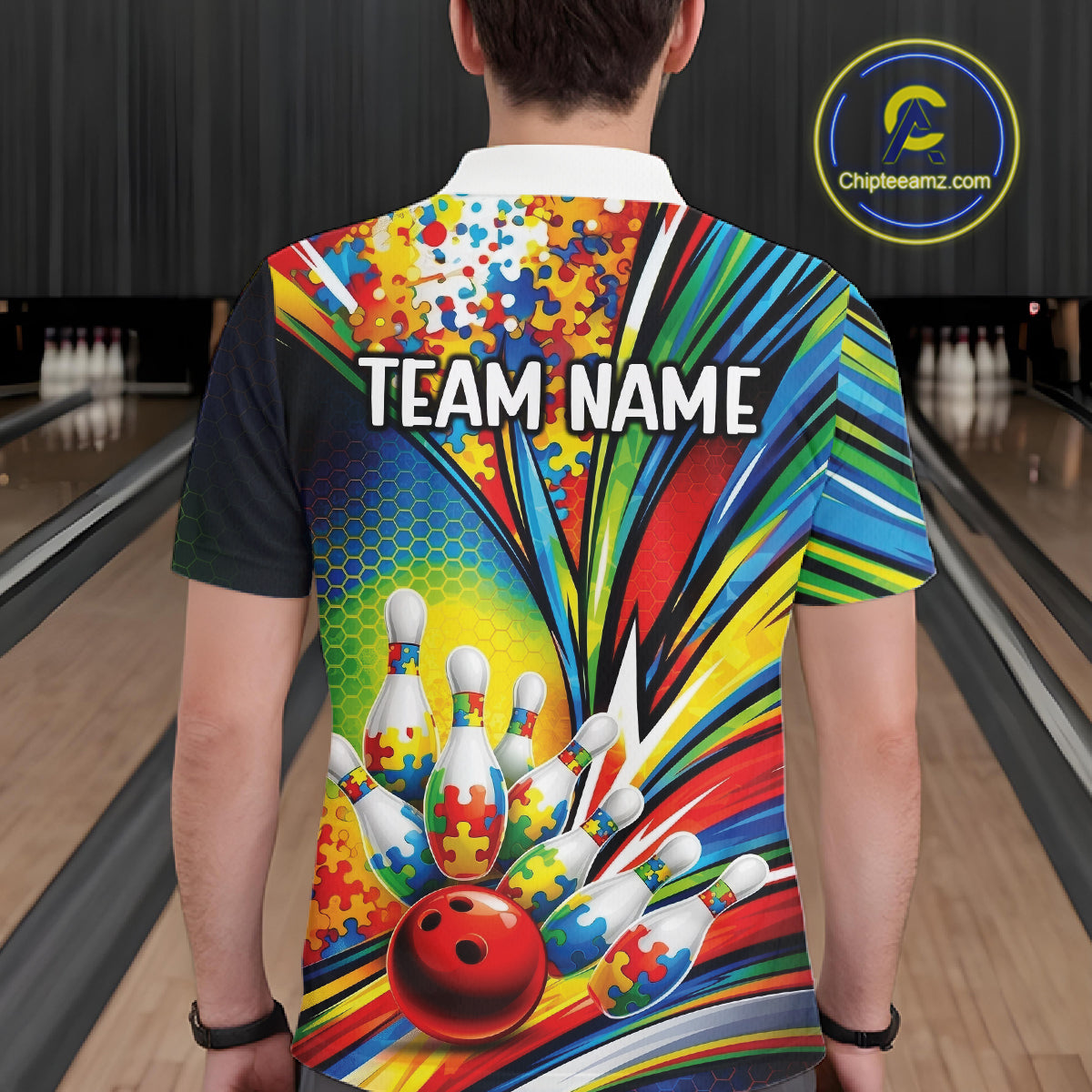 Male model at a bowling lane, back view of white polo shirt featuring colorful autism bowling strike artwork with puzzle accents