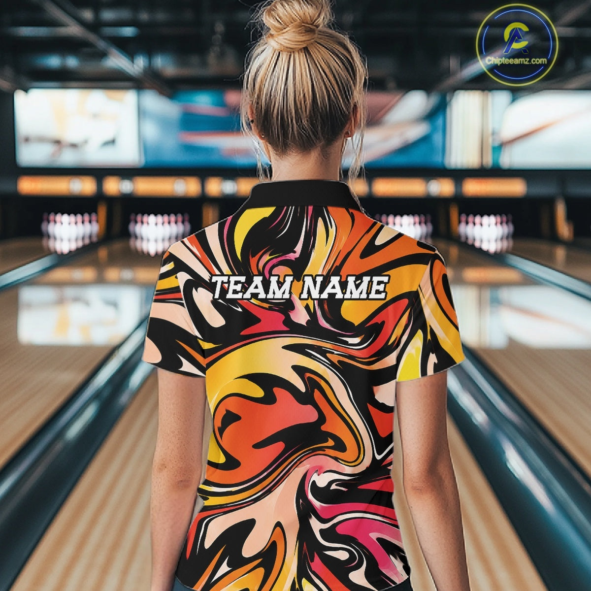 Person wearing a colorful bowling shirt with 'TEAM NAME' text in a bowling alley.