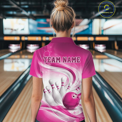 Back view of a female model wearing a white and pink bowling polo shirt in a bowling alley featuring flowing abstract wave patterns and a glossy bowling ball striking a set of pins