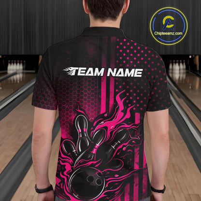 Back view of a male model in a bowling lane wearing a black and pink polo shirt featuring flames around a bowling ball striking pins in a patriotic American flag bowling style.