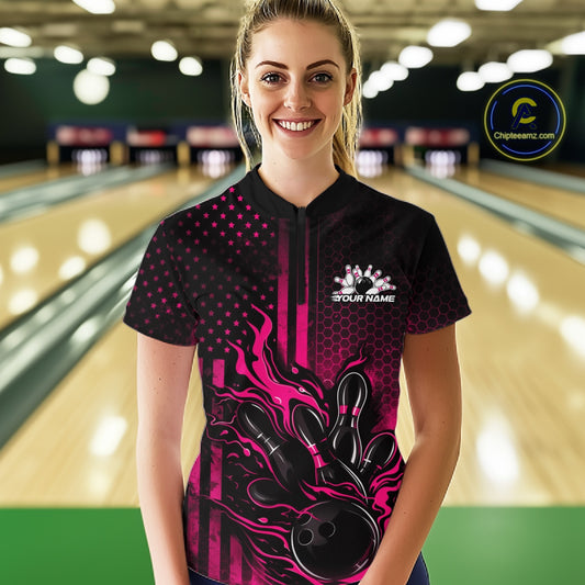 Female model wearing a black and pink bowling quarter-zip shirt at a bowling lane with fiery bowling strike graphics and patriotic styling.