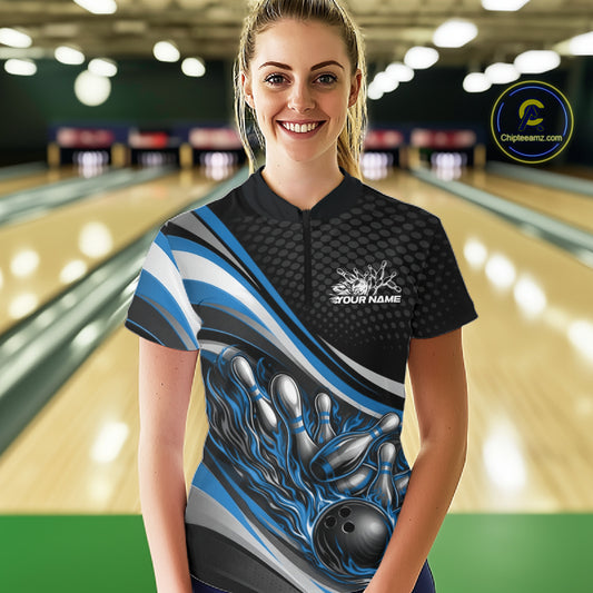 Front view female model wearing black and blue quarter zip bowling shirt in bowling lane, dynamic flame bowling ball and pins artwork