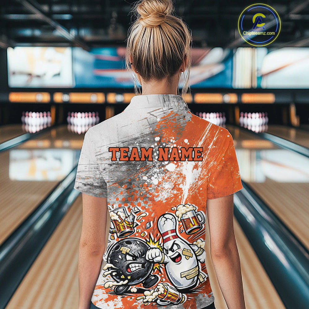 Back view of a female model in a bowling lane wearing an orange and white grunge splatter polo shirt featuring humorous bowling ball and pin battle artwork.