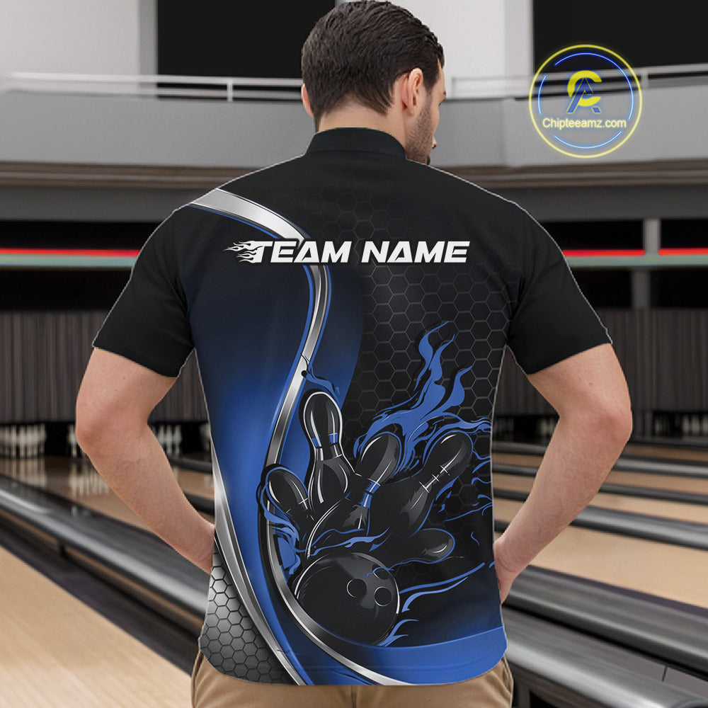 Male model front view inside bowling venue wearing black and blue quarter zip shirt with flaming bowling ball hitting pins graphics