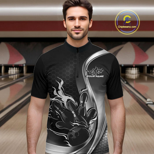 Male model front view at bowling lane wearing black and gray quarter zip shirt with flame bowling ball hitting pins design