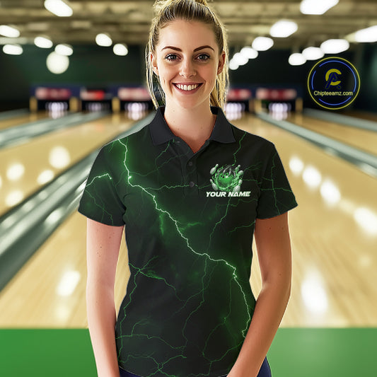 Female model at the bowling lane wearing a black and green bowling polo with fantasy dragon claw artwork and fiery bowling details.