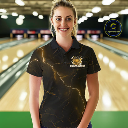 Female model wearing a black and yellow bowling polo with dragon claw artwork, flaming bowling ball, and lightning fantasy background.