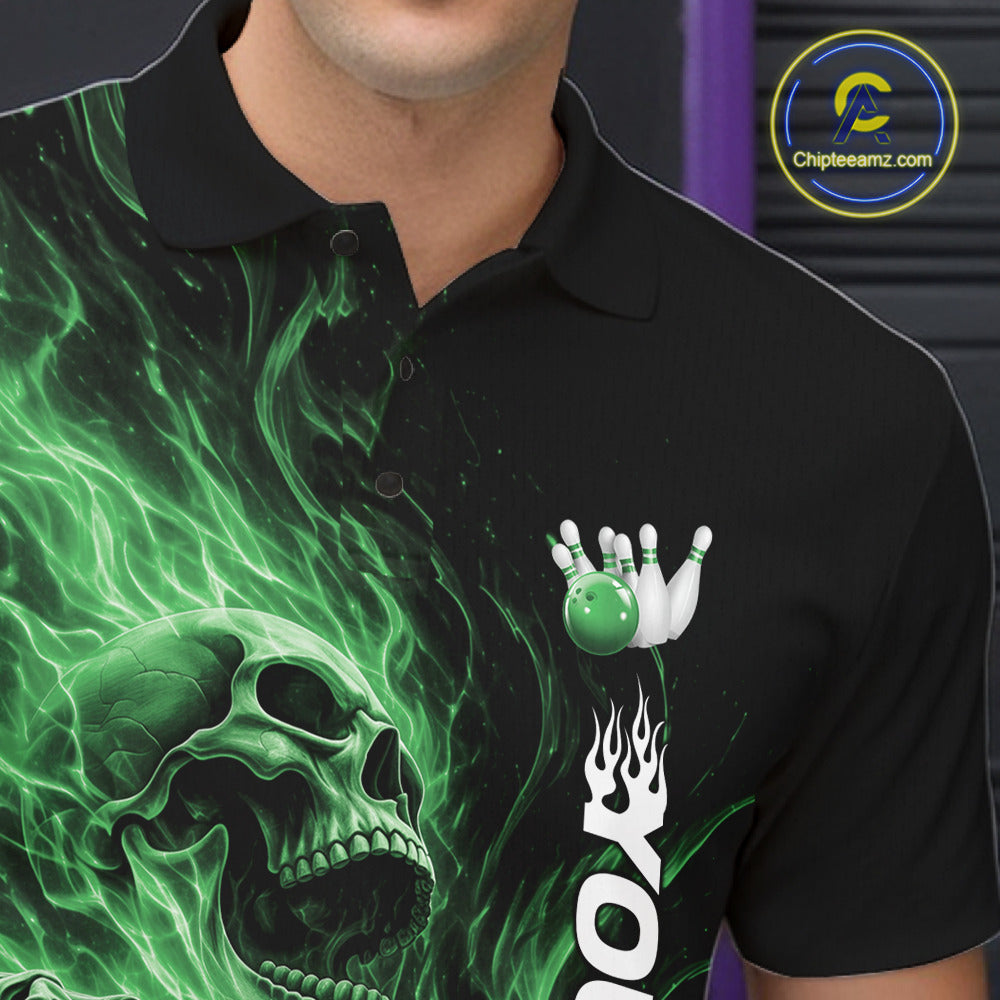 Close-up of the left chest on a black bowling polo shirt featuring a skull clutching a bowling ball with swirling green energy flames