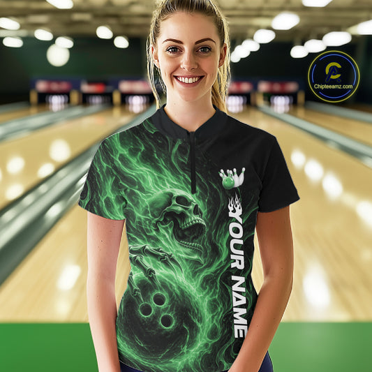 Female model wearing a black bowling quarter-zip shirt in a bowling alley featuring a skull clutching a bowling ball surrounded by swirling green energy flames