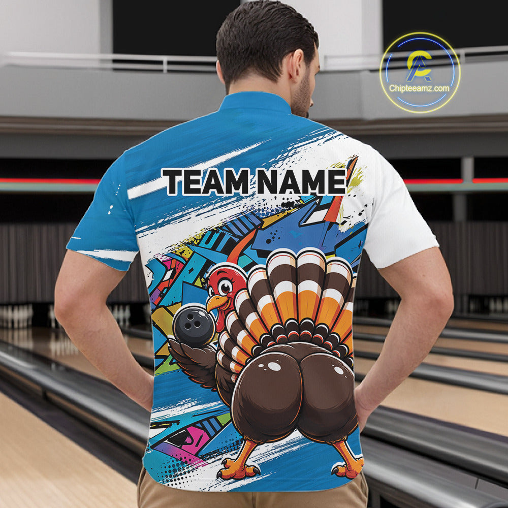 Back view of a male model wearing a blue custom quarter zip bowling shirt with a funny graffiti turkey holding a bowling ball, paint splatter accents in a bowling alley.