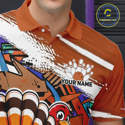 Close up front view of the left chest area on an orange custom bowling polo shirt, featuring a graffiti inspired urban street style design with paint splatter accents and a personalized name.