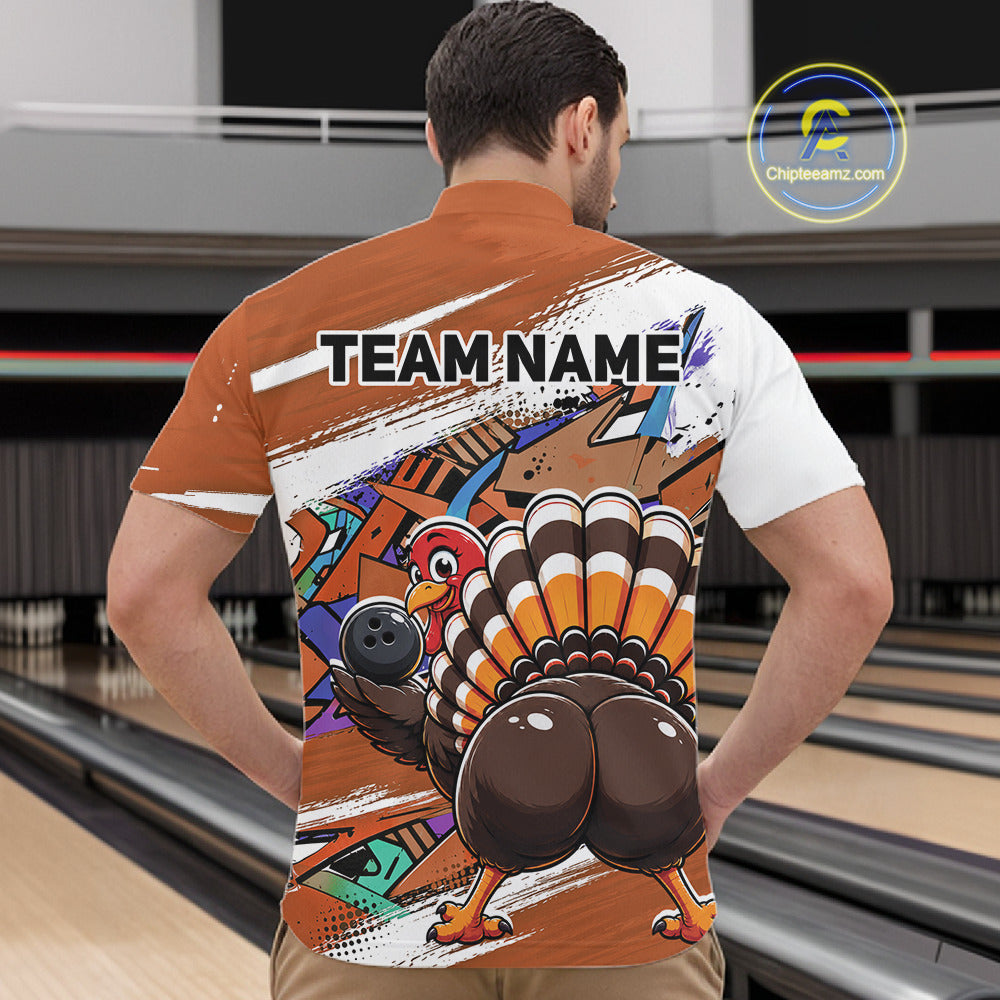 Back view of a male model wearing an orange custom quarter zip bowling shirt with a funny graffiti turkey holding a bowling ball, paint splatter accents in a bowling alley.