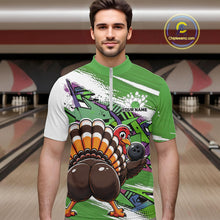 Load image into Gallery viewer, Front view of a male model wearing a green custom quarter zip bowling shirt with a funny graffiti turkey holding a bowling ball, paint splatter accents in a bowling alley.