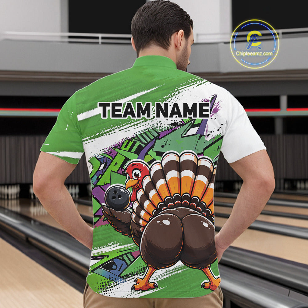 Back view of a male model in a bowling alley wearing a green custom quarter zip bowling shirt with a funny graffiti turkey holding a bowling ball, paint splatter accents, and a personalized name.