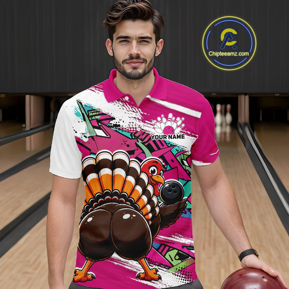 Front view of a male model wearing a pink custom bowling polo shirt featuring a funny graffiti style turkey holding a bowling ball, paint splatter details, and a custom name in a bowling alley.