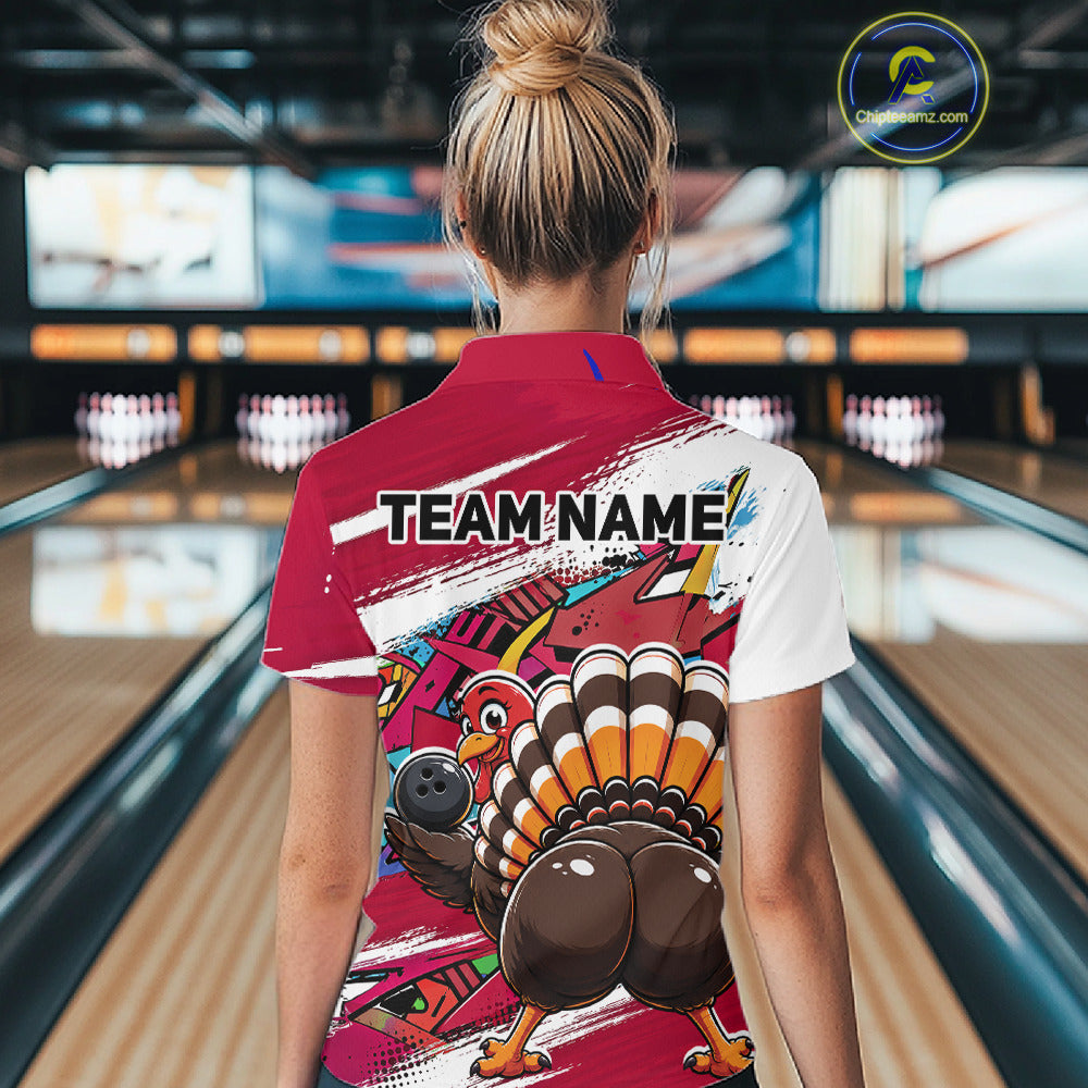 Back view of a female model wearing a red custom bowling polo shirt with a funny graffiti turkey holding a bowling ball, paint splatter accents, and a personalized name in a bowling alley.