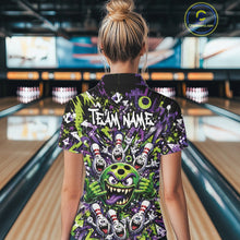 Load image into Gallery viewer, Back view of a female model in a bowling lane wearing a green and purple bowling polo shirt showcasing a mischievous green monster bowling ball with sharp teeth, a purple tongue, playful hand gesture, and cheerful cartoon bowling pins.
