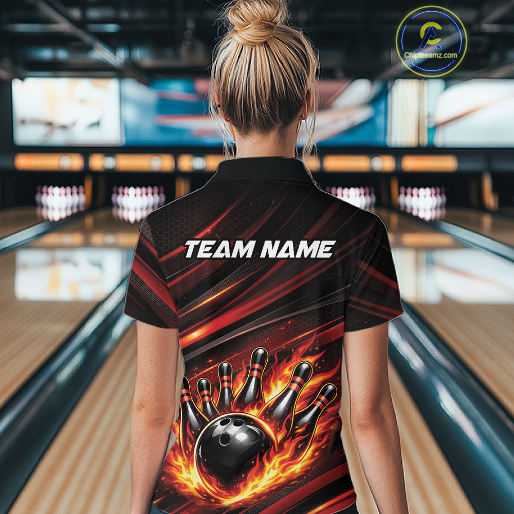 Back view of a female model in a bowling alley wearing a black and red-orange polo shirt featuring a bowling ball knocking down pins.