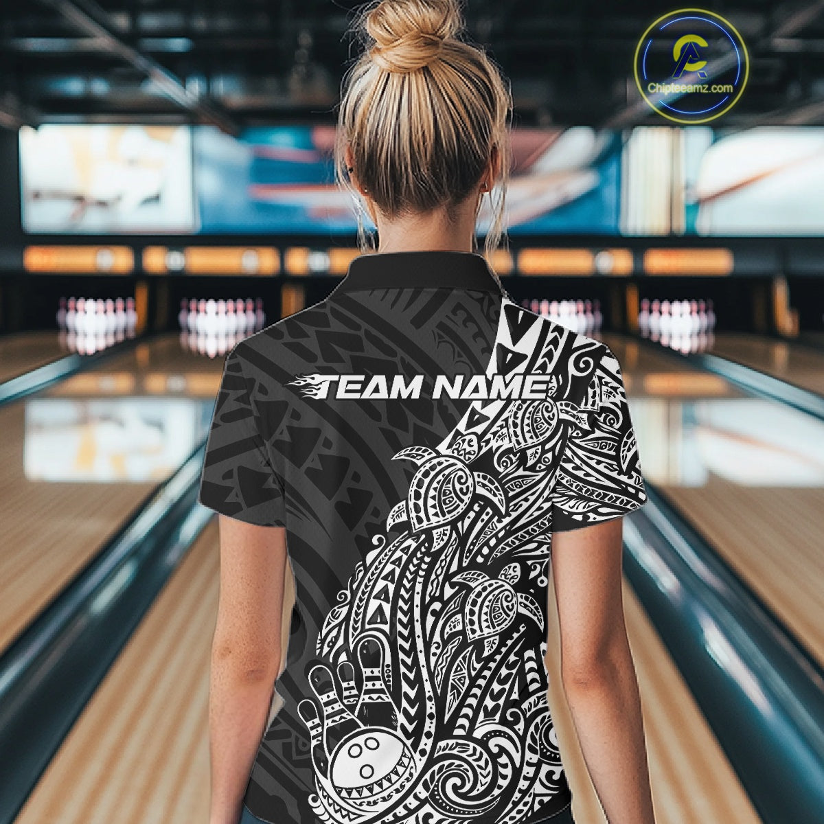 Back view of a female model in a black and white bowling polo shirt displaying Polynesian-style bowling artwork.