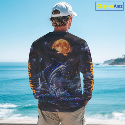 A man stands with his back to the camera wearing a long-sleeve graphic shirt featuring a large fish and a full moon under a starry night sky, with orange text down the sleeves, set against a beach background. A 'ChipteeAmz' logo is visible in the top right corner.