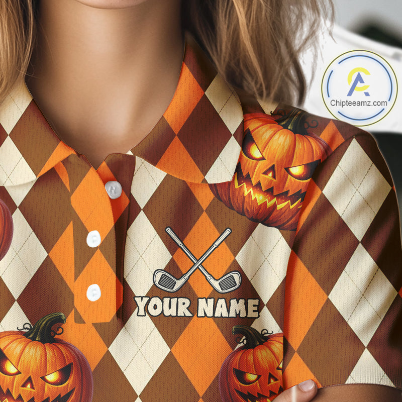 A close-up of a person wearing a short-sleeve collared button-up shirt with a Halloween argyle pattern in orange, brown, and cream. The shirt features jack-o'-lantern graphics, crossed golf clubs, and a customizable text placeholder reading 'YOUR NAME'.