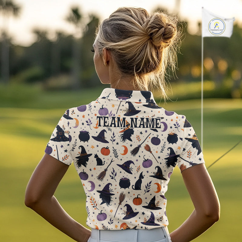 A woman on a golf course seen from behind, wearing a short-sleeve collared golf shirt with a Halloween-themed print of witches, cats, pumpkins, and moons on a cream background. The back of the shirt has 'TEAM NAME
