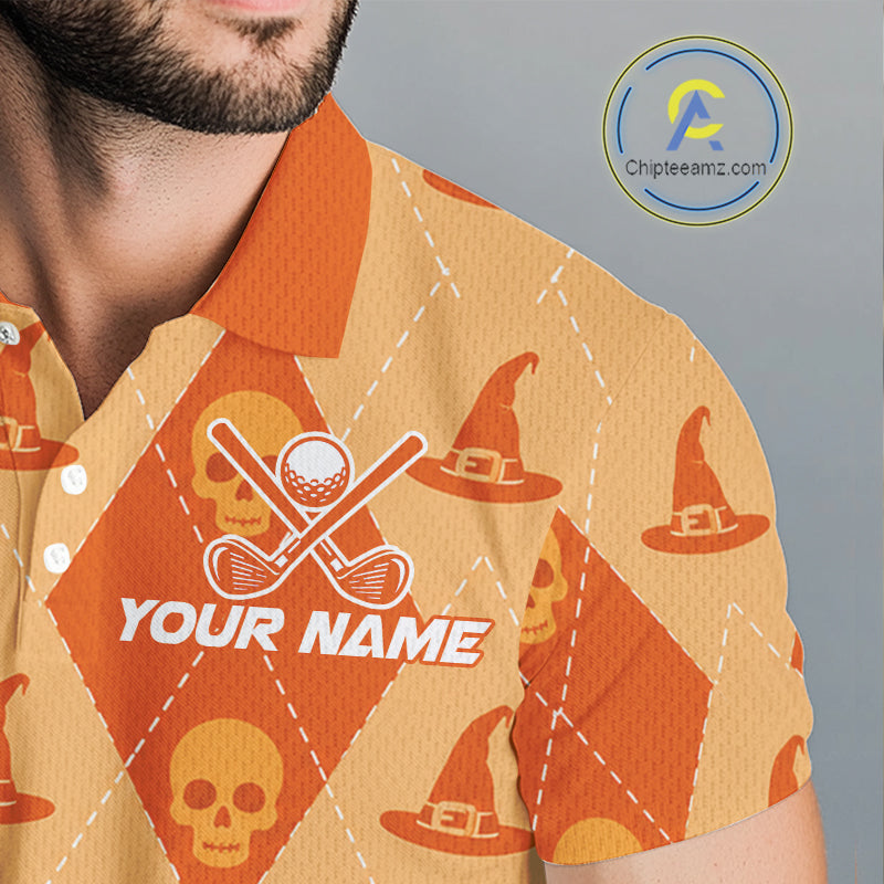 A close-up of a man wearing a short-sleeve polo shirt with a Halloween-themed pattern of orange skulls, witch hats, and crossed golf clubs on a beige and orange diamond design. The shirt features a customizable text placeholder 'YOUR NAME'.