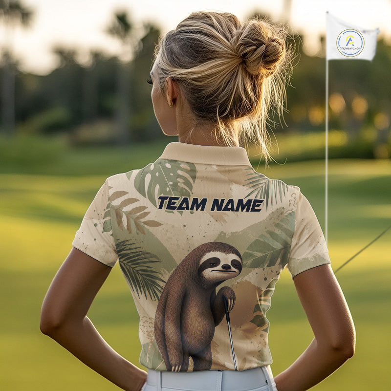 A woman on a golf course seen from behind, wearing a short-sleeve polo shirt with a tropical leaf pattern and a sloth graphic on the back, with 'TEAM NAME' printed above the graphic.