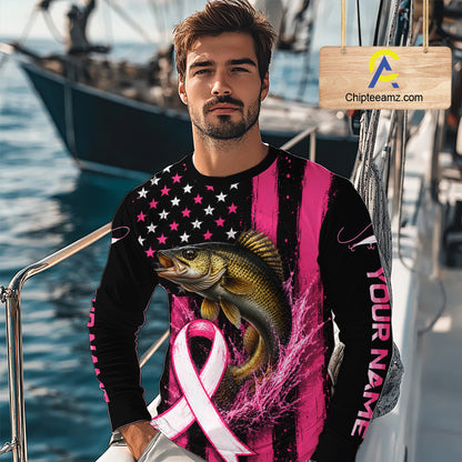  man wearing a long-sleeve black and pink graphic shirt with a large fish and pink ribbon print, standing on a boat deck with water and boats in the background. A wooden sign with the text 'Chipteeamz.