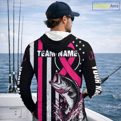 A man on a boat wearing a black long-sleeve fishing hoodie with a pink and white patriotic fish graphic, stars, and customizable text. The background shows the ocean and sky.