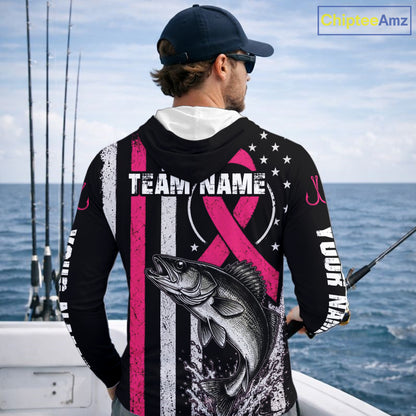 A man on a boat shown from behind wearing a custom black long-sleeve fishing hoodie with a pink and white striped design, a large bass graphic, and customizable text. The background shows the ocean and fishing rods.