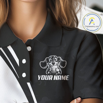 Close-up of a person wearing a black polo shirt with a white printed dachshund graphic and the text 'YOUR NAME' on the chest. The image includes a circular 'Chipteeamz.