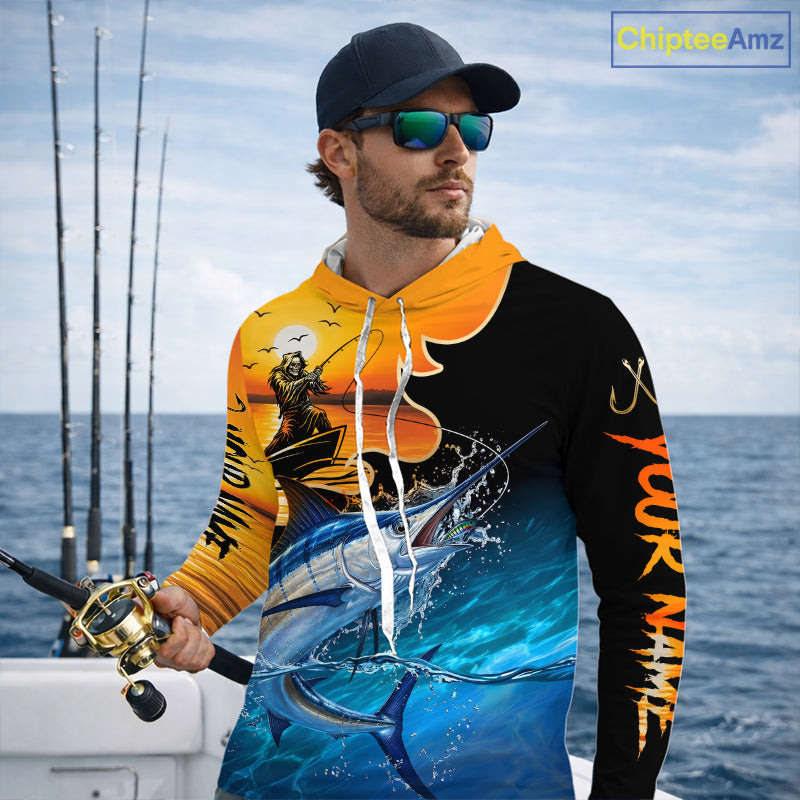 Man wearing a colorful long sleeve hooded fishing shirt with a design of a marlin fish and a fish reaper, standing on a boat with fishing rods in the background.
