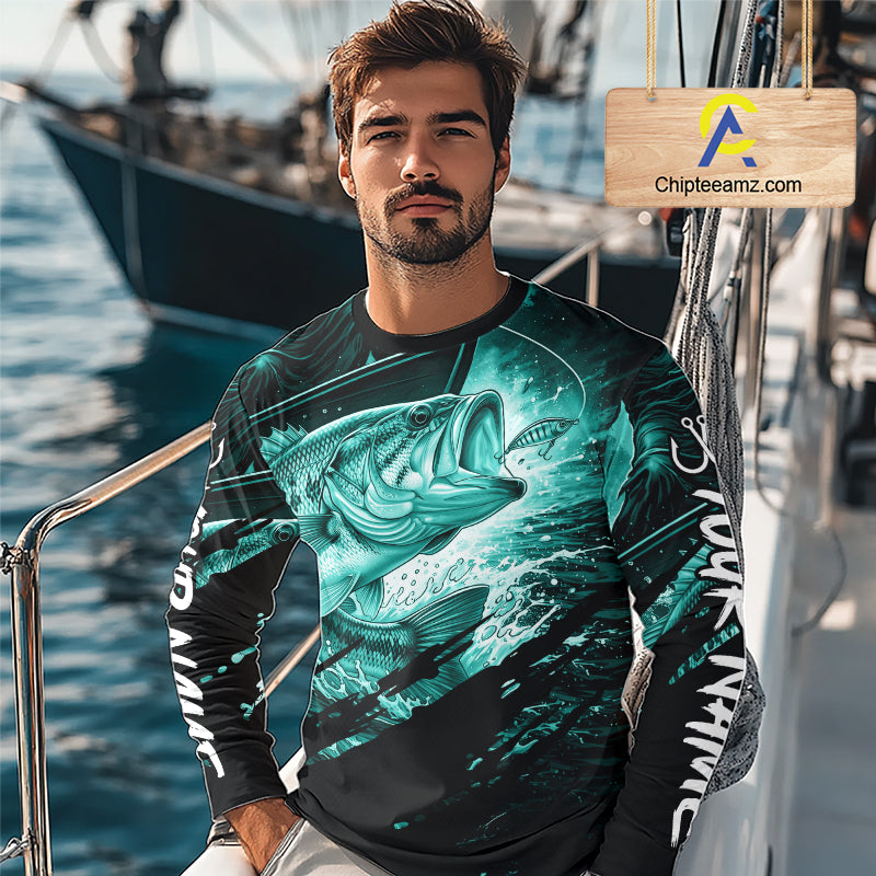 Man wearing a long sleeve fishing shirt with a teal bass fish design on a boat