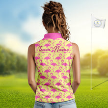 Load image into Gallery viewer, Woman wearing a yellow sleeveless polo shirt with pink flamingo pattern and 'Team Name' text on the back, standing on a golf course.