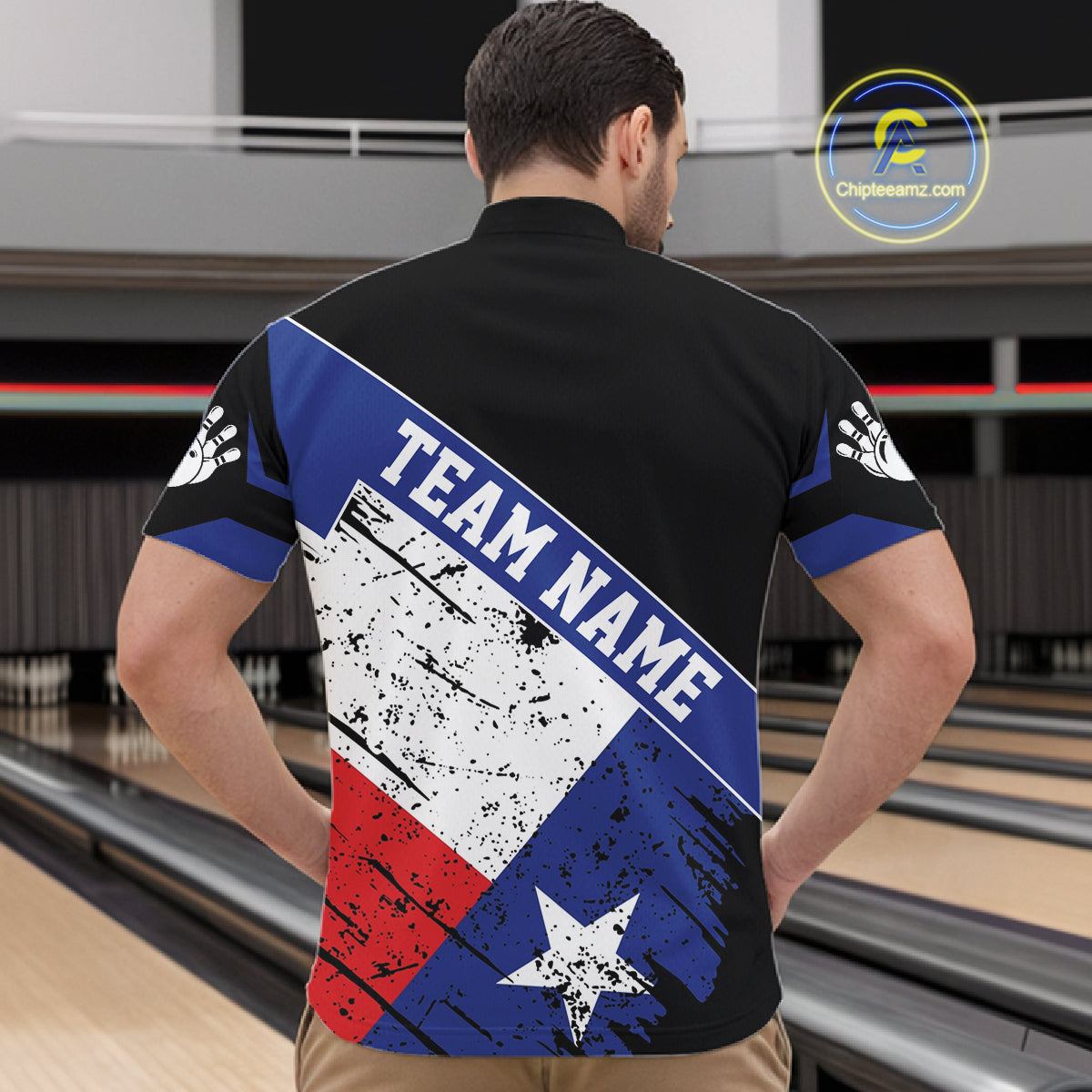 Back view of man wearing a grunge Texas flag bowling quarter zip shirt in a bowling alley.