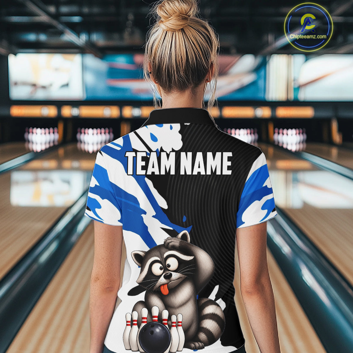 Person wearing a bowling shirt with a raccoon graphic and 'Team Name' text in a bowling alley.