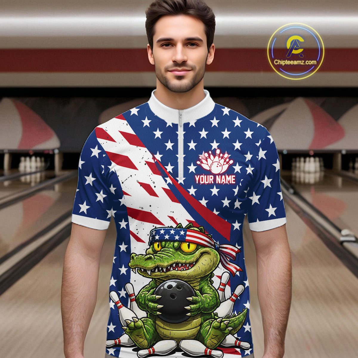 Man wearing a bowling shirt with American flag design and a green alligator holding a bowling ball in a bowling alley.