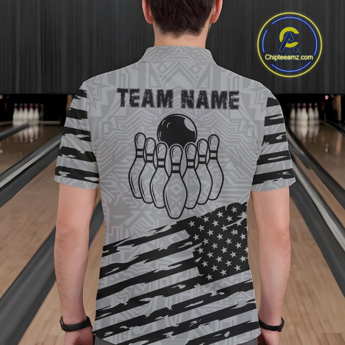 Back view of man wearing a grey American flag bowling polo shirt inside a bowling alley.