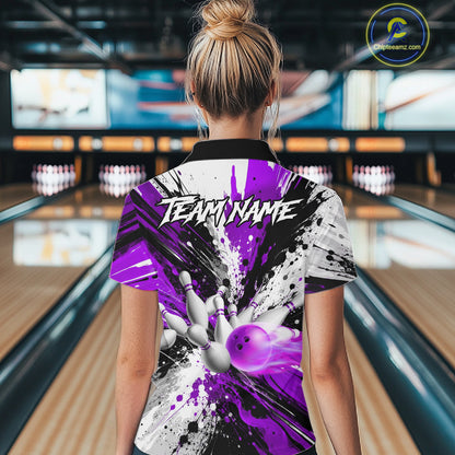 Back view of woman wearing a purple splatter bowling polo shirt inside a bowling alley.